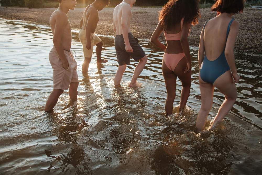 A group of men and women in swimsuits at the seaside.