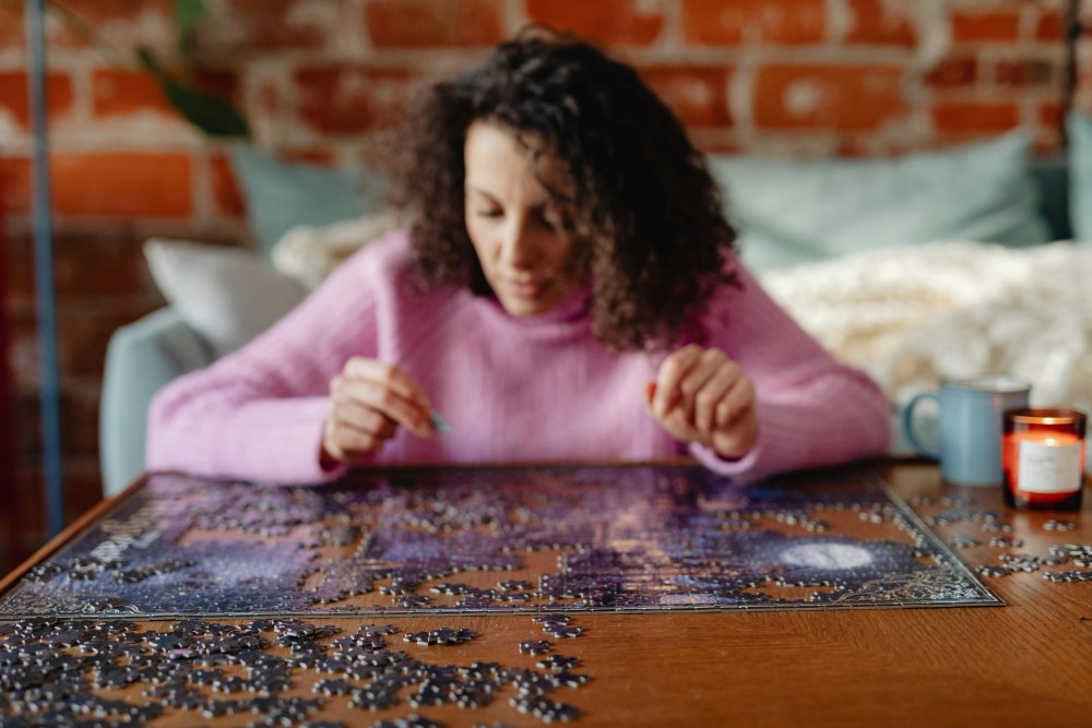 A woman is doing a jigsaw puzzle.